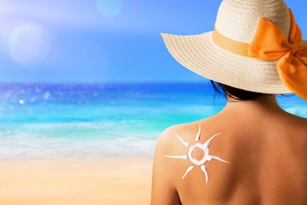 Solkräm på kvinna på stranden