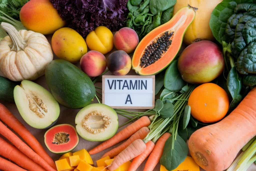 Färska frukter och grönsaker som är rika på A-vitamin, med en skylt som visar texten "Vitamin A".